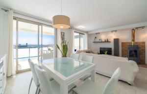 a living room with a glass table and white chairs at Bellavista 2 sea views in Alcudia