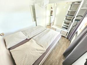 クックスハーフェンにあるAppartementhaus-Kogge-Wohnung-11の小さな客室で、ベッド1台、棚が備わります。