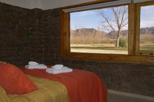 Habitación con cama y ventana con toallas en Cabañas Posada del Angel en Valle Grande