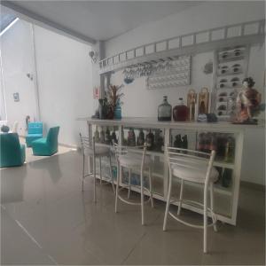 帕拉卡斯的住宿－Hospedaje El Candelabro de Paracas，一间带椅子和一个带瓶子的柜台的房间