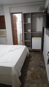 1 dormitorio con cama blanca y armario en POUSADA TAHITI, en Pasto da Mata