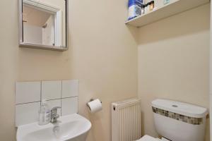 a white bathroom with a toilet and a sink at LiveStay - One Bedroom Studio Near The Beach in Southend-on-Sea