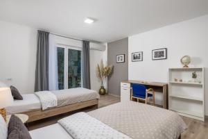 a bedroom with two beds and a desk at Apartment City flower in Rijeka