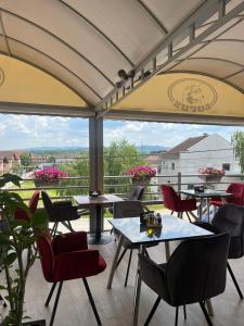 a restaurant with tables and chairs and a balcony at Hotel Lupus in Novi Sad