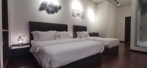 1 dormitorio con 2 camas con edredones blancos en TREASURE HUNTER At Heritage Georgetown, en George Town