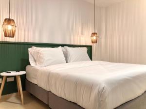 - une chambre avec un grand lit blanc et une table dans l'établissement Minarete By Wynwood House, à Carthagène des Indes