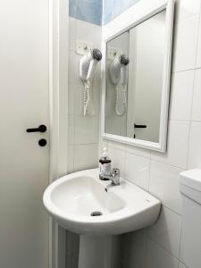 a bathroom with a white sink and a mirror at Mio Hostel in Milan