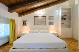 1 dormitorio con 1 cama blanca grande y 2 lámparas en Isaia Garden - BolognaRooms, en Bolonia