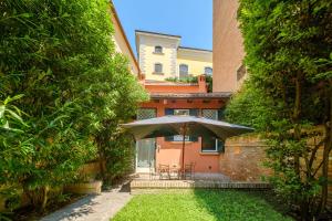 patio con ombrellone di fronte a casa di Isaia Garden - BolognaRooms a Bologna