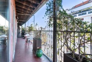 un balcon avec un vase vert assis sur une terrasse couverte dans l'établissement Fifty Eight Suite Milan Sforza, à Milan