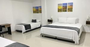 1 dormitorio con 2 camas, escritorio y mesa en Hotel El Marqués De Manga en Cartagena de Indias