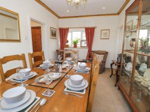 uma sala de jantar com uma mesa de madeira e cadeiras em Cedar Gardens em Llabedr-Dyffryn-Clwyd