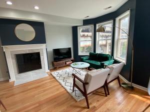 a living room with a green couch and a fireplace at Modern Wrigley Oasis with Parking! in Chicago