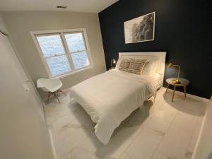 1 dormitorio con cama blanca y ventana en Modern Wrigley Oasis with Parking! en Chicago