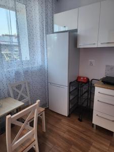 kuchnia z lodówką, stołem i krzesłami w obiekcie Przytulne, nowoczesne mieszkanie 2 Br w mieście Rzeszów