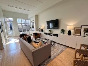 a living room with a couch and a tv at Old Town Pied-a-Terre with Private Terrace and Parking! in Chicago