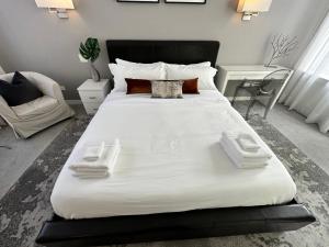 a large bed with two towels on it in a bedroom at Old Town Pied-a-Terre with Private Terrace and Parking! in Chicago