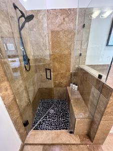a bathroom with a shower with a glass door at Old Town Pied-a-Terre with Private Terrace and Parking! in Chicago