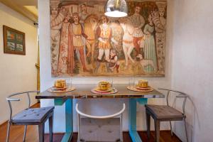 une table avec deux chaises et un tableau sur le mur dans l'établissement Fifty Eight Suite Milan Sforza, à Milan