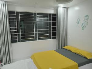 une chambre avec un lit jaune et une fenêtre dans l'établissement Huế Thơ Homestay, à Hue