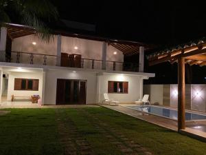 uma casa grande com piscina à noite em Casa Barra Grande em Maraú