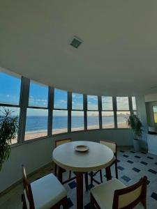 a table and chairs in a room with a view of the beach at Bela Vista Copacabana in Rio de Janeiro