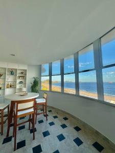 a dining room with a table and chairs and the ocean at Bela Vista Copacabana in Rio de Janeiro