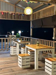 a patio with tables and benches on a deck at BIHING ANGAN water chalet in Semporna