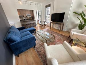 ein Wohnzimmer mit einem blauen Sofa und einem TV in der Unterkunft River North Hideaway with Amazing Views and Parking in Chicago
