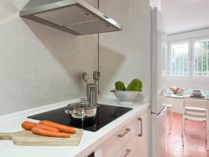 a kitchen with a stove top with carrots on a counter at Apartamentos Gredos 201 in Jaraiz de la Vera