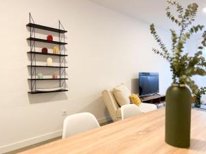 a dining room with a table and a vase with a plant at Apartamentos Gredos 201 in Jaraiz de la Vera