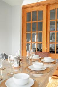Enjoy a Luxury & Peaceful Home in Loughton, Essex في لوثيون: طاولة عليها صحون واكواب للنبيذ