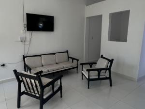 a living room with a couch and two chairs at Loft Vacacional in Mariquita