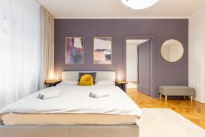 ブラチスラヴァにあるLuxury Apartment on Wilsonova, close to City Centerの紫の壁のベッドルーム1室(白い大型ベッド1台付)