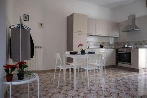 a kitchen with white chairs and a white table at Classy House in Marigliano in Marigliano