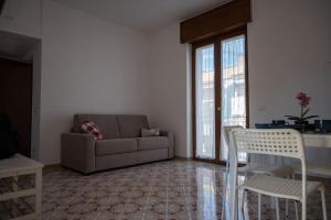 uma sala de estar com um sofá, uma mesa e cadeiras em Classy House in Marigliano em Marigliano