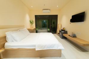a bedroom with a large white bed and a flat screen tv at Khách sạn Gấu Hotel in Hanoi