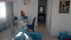 帕拉卡斯的住宿－Hospedaje El Candelabro de Paracas，客厅配有蓝色的椅子和桌子
