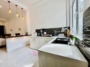 een keuken met witte kasten, een gootsteen en een raam bij The Palazzo - Weligama in Weligama