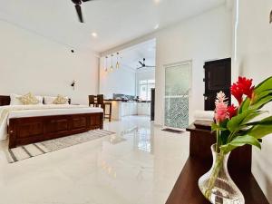 een woonkamer met een bed en een vaas met bloemen bij The Palazzo - Weligama in Weligama