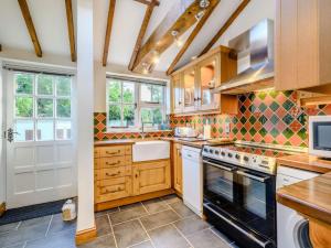 a kitchen with white appliances and wooden cabinets at 3 Bed in Aldborough 85528 in Thurgarton