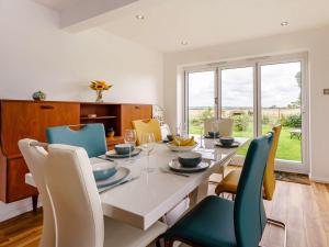 a dining room with a white table and chairs at 3 Bed in St Marys Bay 86012 in Dymchurch