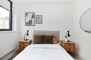 a bedroom with a bed and two night stands at The Wembley Escape - Lovely 2BDR Flat in London