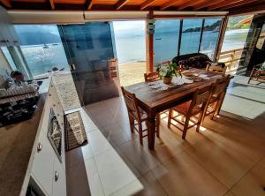 a dining room with a table and a view of the ocean at Casa charmosa pé na areia por do sol in Florianópolis