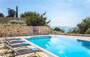 a swimming pool with chairs next to a stone wall at Delightful Kefalonia Villa 3 Bedrooms Villa Mare Blue Private Pool & Close To Amenities Trapezaki in Kefallonia