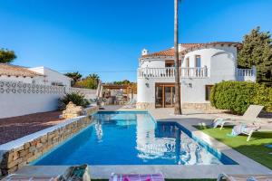 a villa with a swimming pool in front of a house at Villa K9 Ortenbach in Ifach