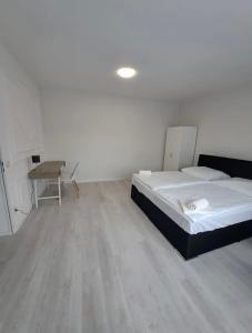 1 dormitorio con cama, escritorio y mesa en MyCompass Hotel Offenbach en Offenbach