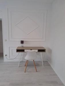 a wooden desk with a white chair in a room at MyCompass Hotel Offenbach in Offenbach