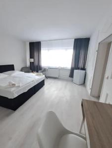 duży pokój z łóżkiem i krzesłem w obiekcie MyCompass Hotel Offenbach w mieście Offenbach