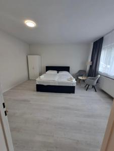 1 dormitorio con 1 cama y 1 silla en MyCompass Hotel Offenbach en Offenbach